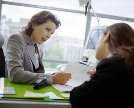 Two women discussing paperwork