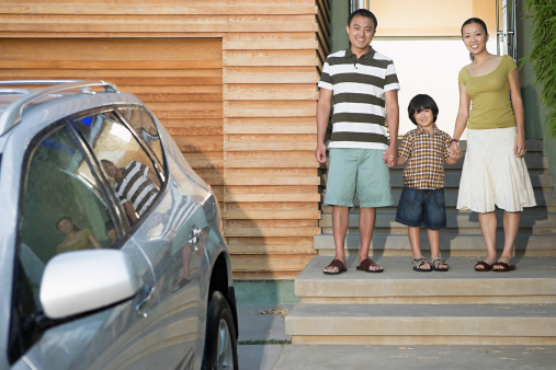 Family Standing in Front of Home and Car
