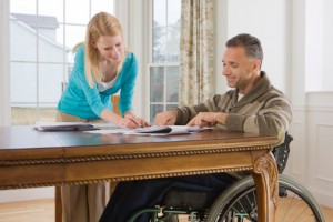 Woman Assisting Man in Wheelchair with Paperwork
