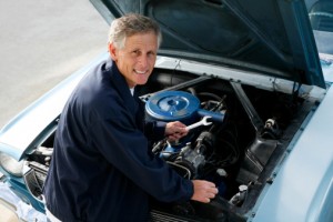 Man Examining Engine of a Vintage Car