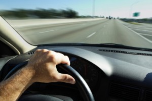 Hands Driving Steering Wheel on the Road
