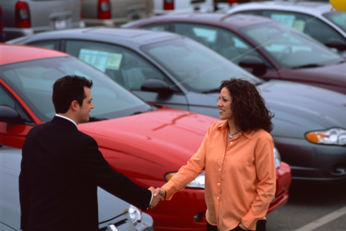 Woman and Man Shaking Hands at Car Dealership