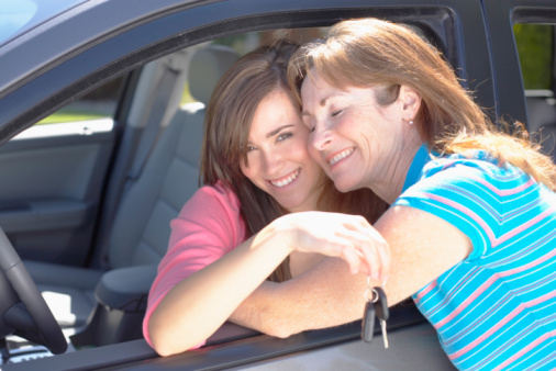 Mother Embracing Teen Daughter and Car