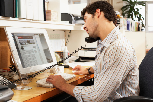Man Talking on the Phone at His Office Desk