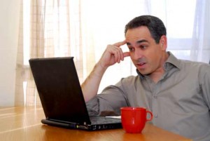 Man Thinking and Looking at Laptop