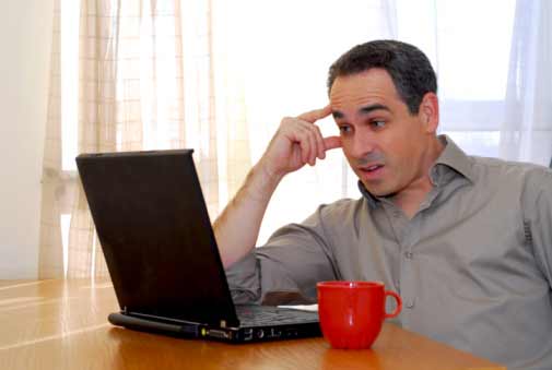 Man Thinking and Looking at Laptop